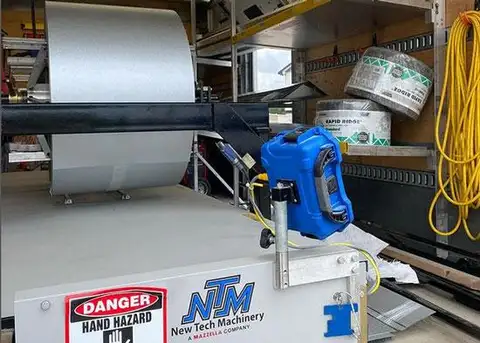 Metal bender producing roofing panels
